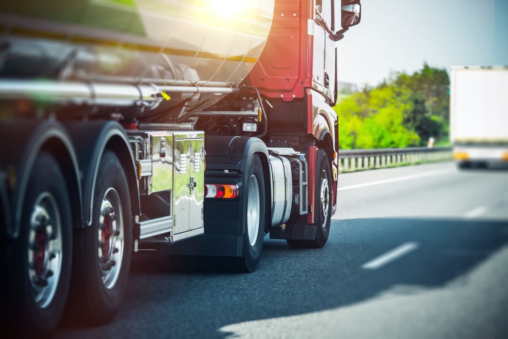 A closeup view of a semi-truck's tires on the road