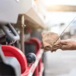 Man checking the oil dip stick on a semi truck.