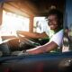 Young male driver in the seat of a semi-truck.