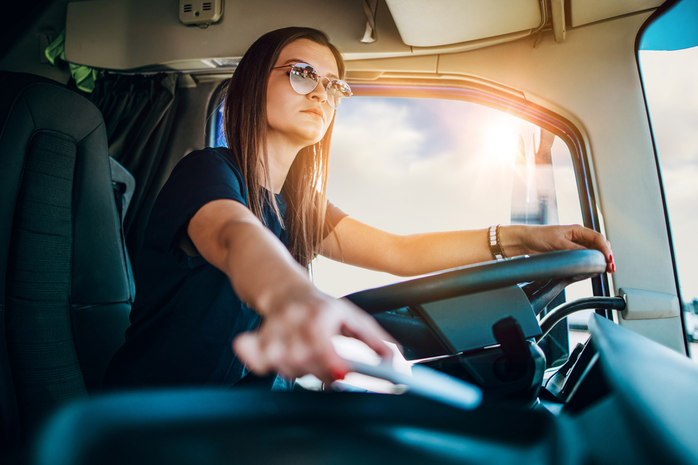 Woman in semi-truck cab.