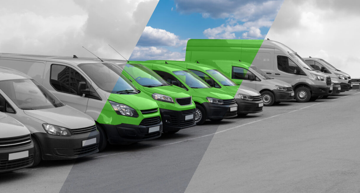 A black-and-white photo of a row of vans with a streak running diagonally through it revealing that the vans are green.