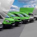 A black-and-white photo of a row of vans with a streak running diagonally through it revealing that the vans are green.