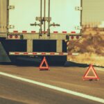 Semi-truck on the side of the road with triangular safety reflectors