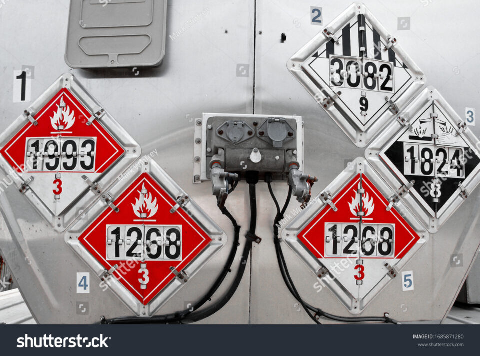 Rear of a tanker truck with placards displaying 1268 and 3082 chemical warnings.