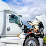 White semi-truck cab with an open hood.