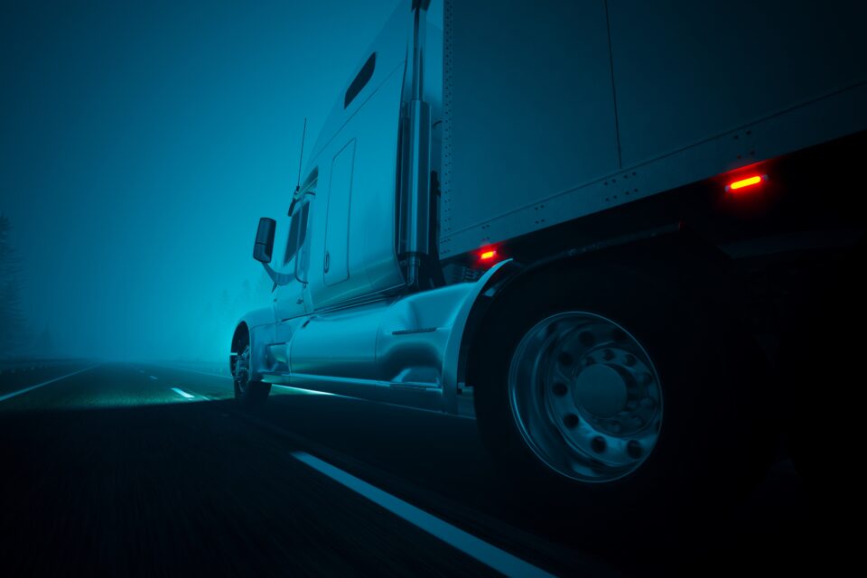 Semi-truck on the road, at night.