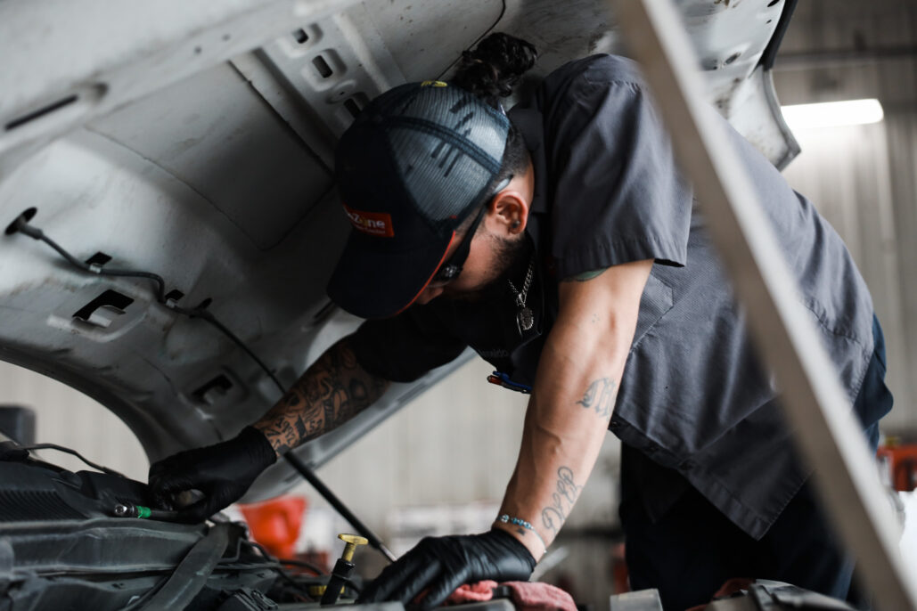Mechanic working under an open vehicle hood
