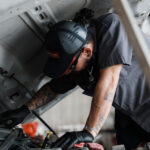 Mechanic working under an open vehicle hood