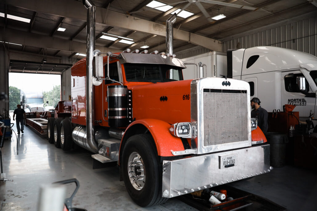 Orange semi-truck in a service garage