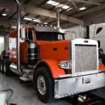 Orange semi-truck in a service garage