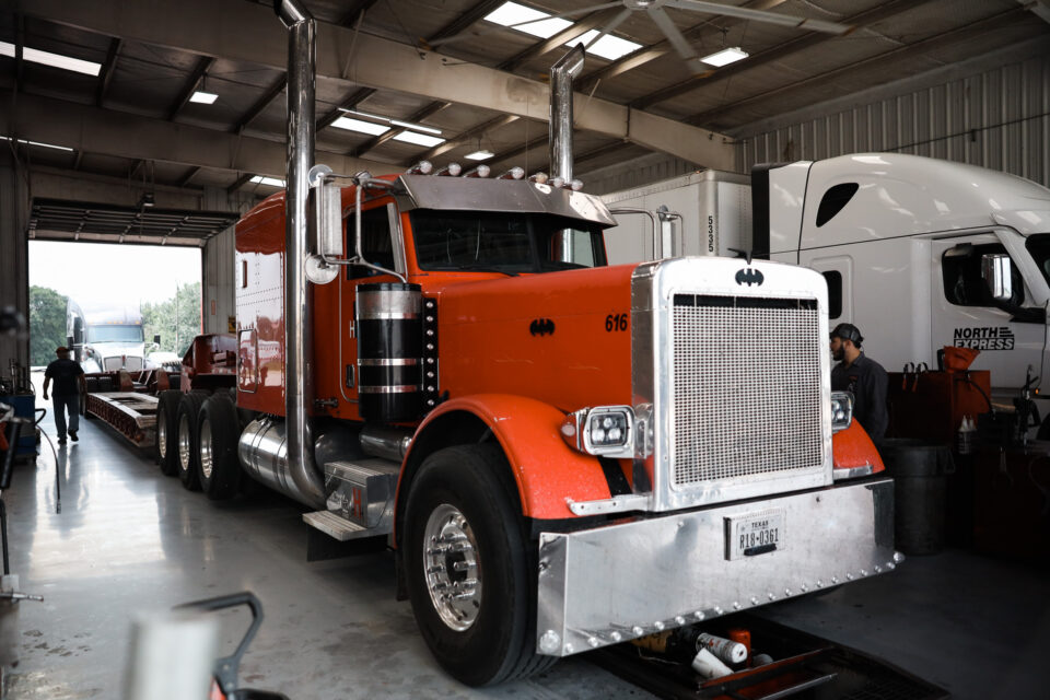 Orange semi-truck in a service garage